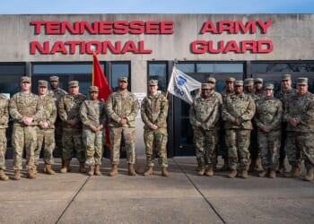 Group of Tennessee National Army Guard soldiers posing in front of their headquarters building, showcasing military camaraderie and service commitment.