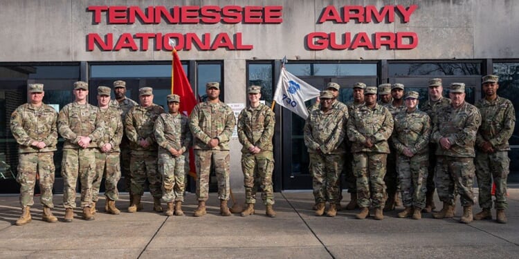 Group of Tennessee National Army Guard soldiers posing in front of their headquarters building, showcasing military camaraderie and service commitment.