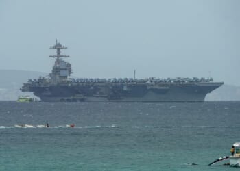The USS Gerald R. Ford aircraft carrier, seen in the distance.