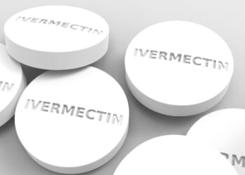 White Ivermectin tablets displayed on a neutral background, highlighting their round shape and embossed lettering.