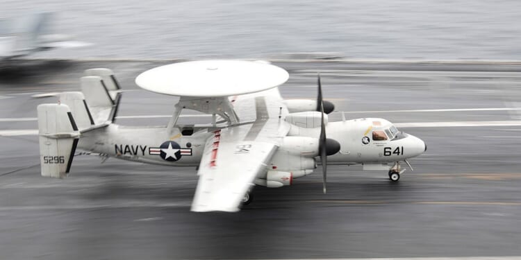 An E-2 Hawkeye landing on an aircraft carrier.