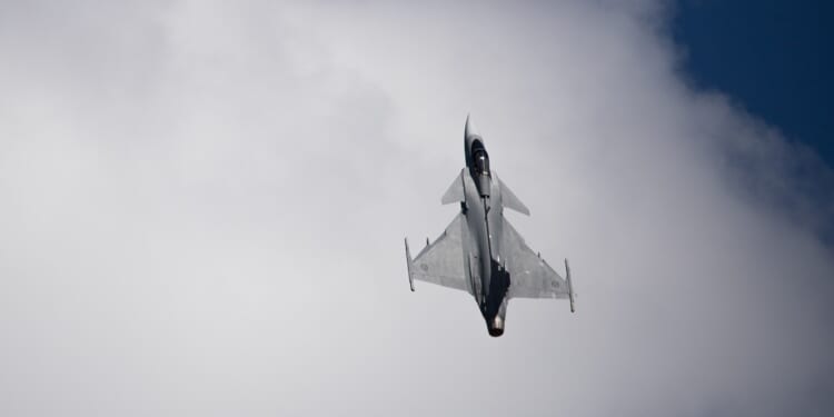 A Swedish JAS 39 Gripen flying vertically.
