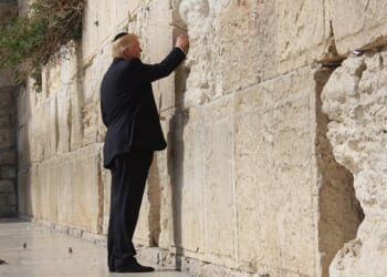 Former U.S. President visiting the Western Wall in Jerusalem, placing a note in the cracks of the ancient stone.