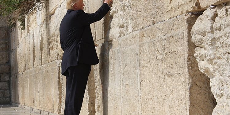 Former U.S. President visiting the Western Wall in Jerusalem, placing a note in the cracks of the ancient stone.