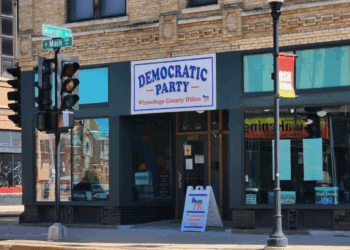 Exterior of the Winnebago County Democratic Party office located at 480 N Main St, featuring a sign and nearby traffic signals.