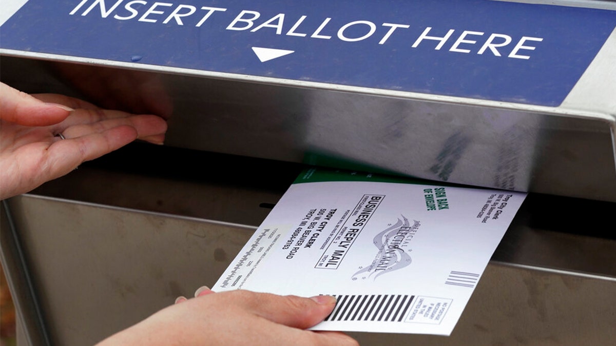 Michigan Ballot Box with person putting envelope in.