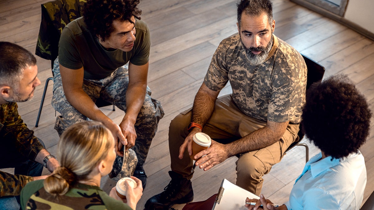 Group of three veterans sitting around discussing mental health.