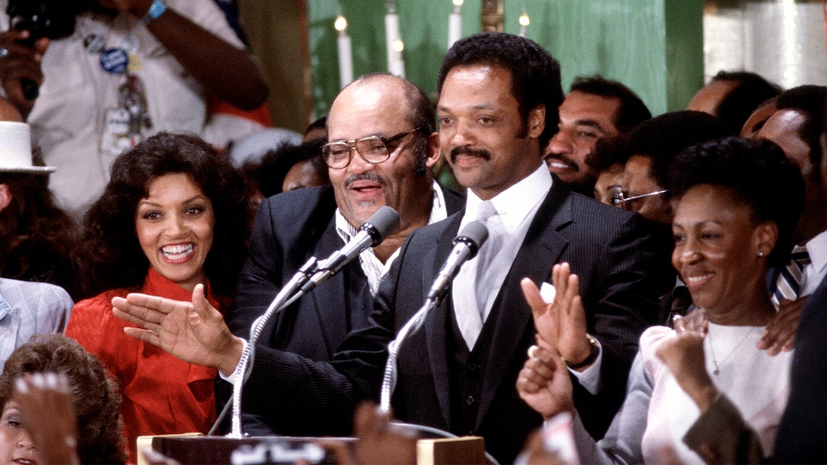 Rev. Jesse Jackson Sr. speaks at a campaign event surrounded by supporters and Rep. Maxine Waters at a Los Angeles hotel.