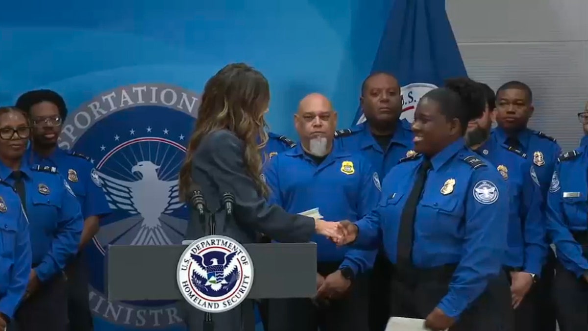Kristi Noem shakes hands with TSA officer