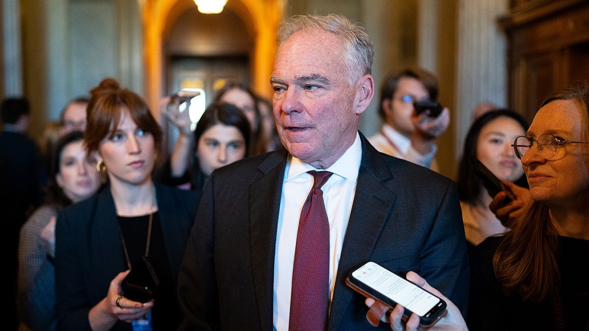 Tim Kaine stands in hallway with reporters outside Senate chamber