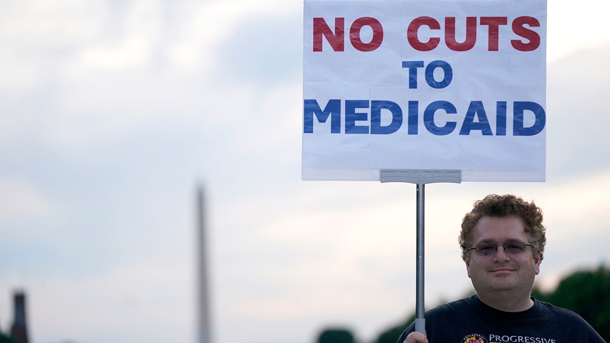 Protester in Washington, D.C. holds sign demanding 'No Cuts To Medicaid'