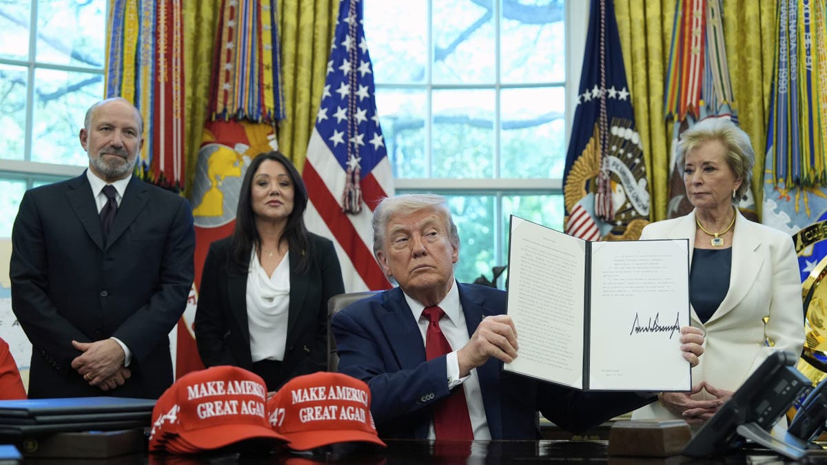 President Donald Trump holds an executive order relating to education in the Oval Office of the White House, Wednesday, April 23, 2025, in Washington, as Commerce Secretary Howard Lutnick, Labor Secretary Lori Chavez-DeRemer and Education Secretary Linda McMahon watch. (AP Photo/Alex Brandon)