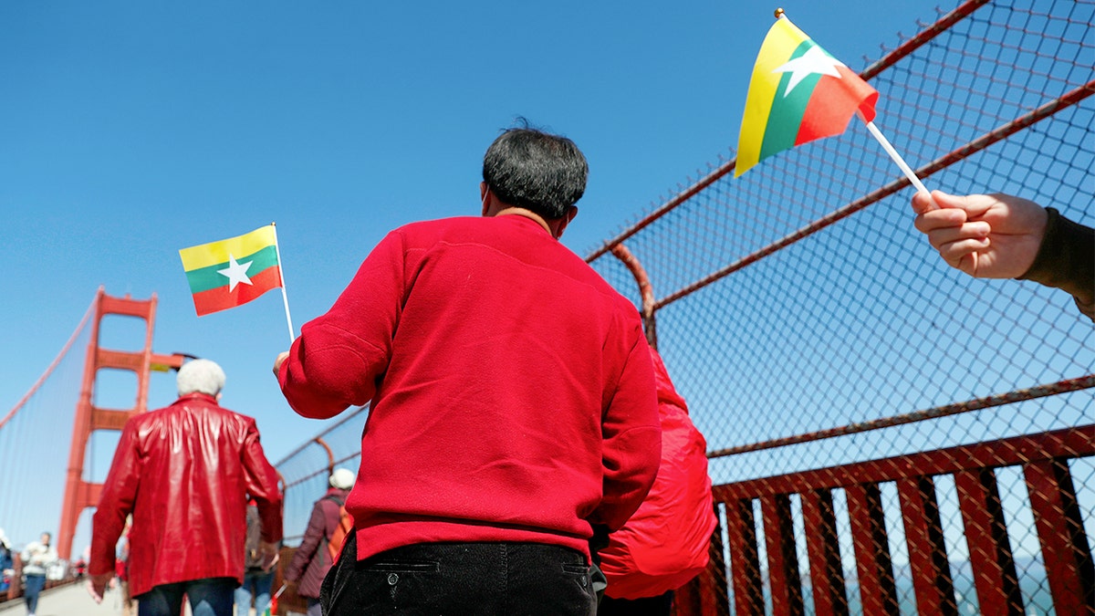 People march in San Francisco while holding Burmese flags