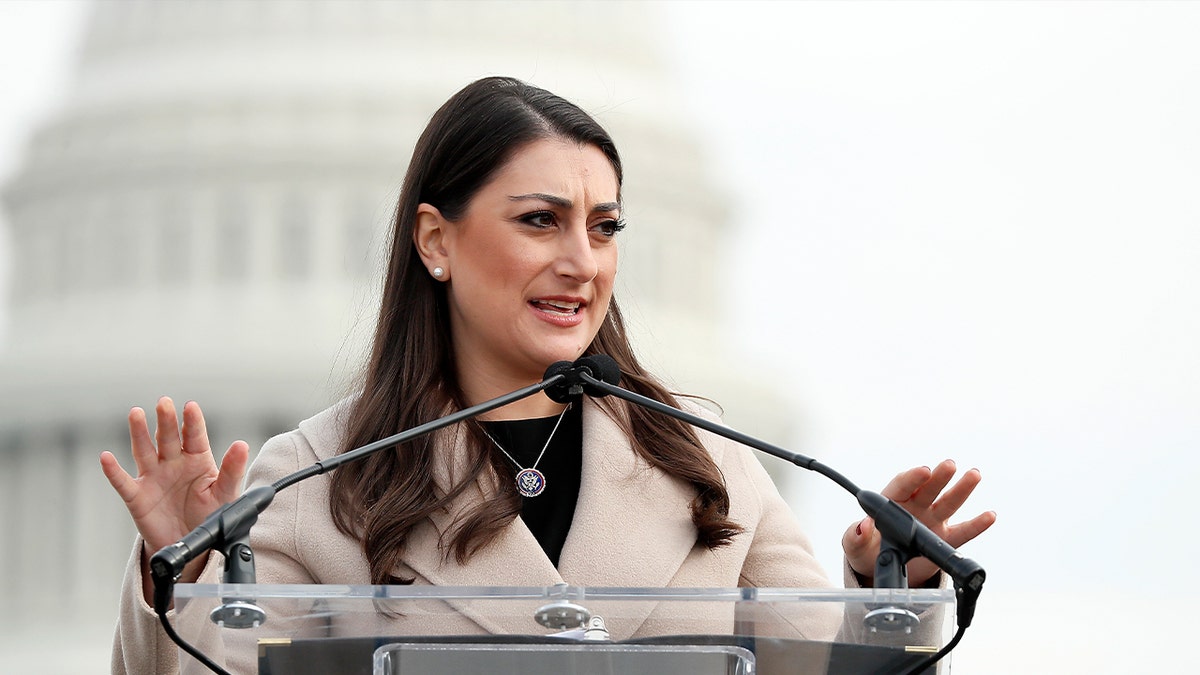 sara jacobs speaking at podium during news conference