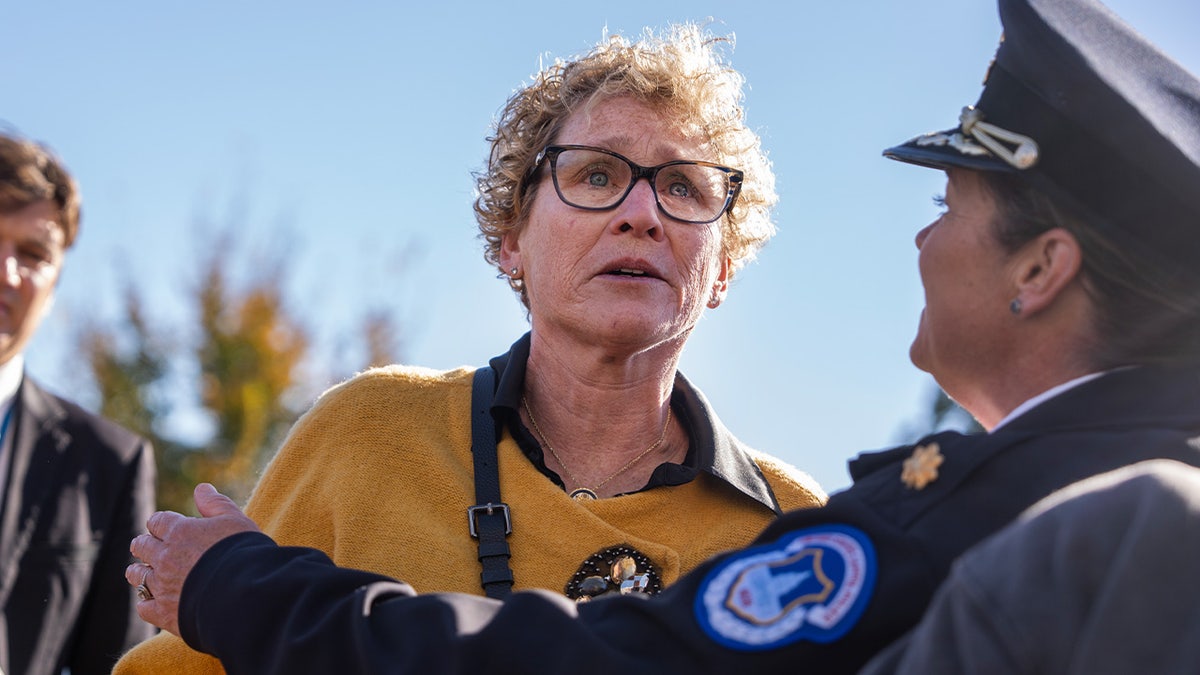 Rep. Chrissy Houlahan being held back by a police officer