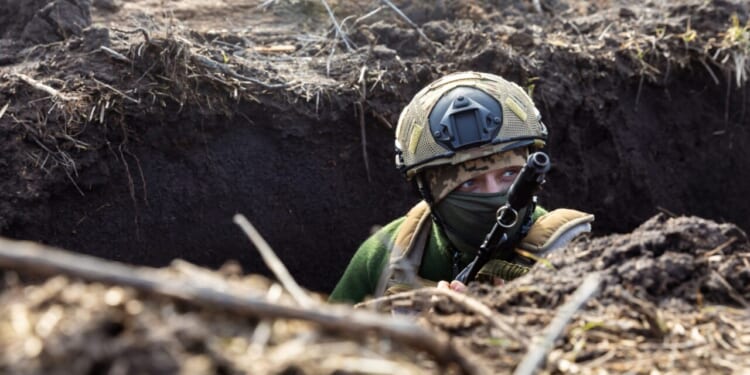 A Ukrainian Armed Forces soldier is seen with a rifle in a trench at a combat position during a combat mission in Donetsk region, Ukraine.