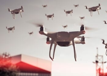 A swarm of drones flying over a city.