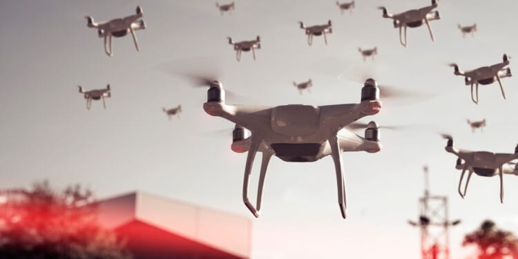 A swarm of drones flying over a city.