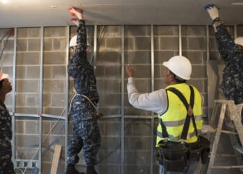 A group of soldiers participating in a construction project.
