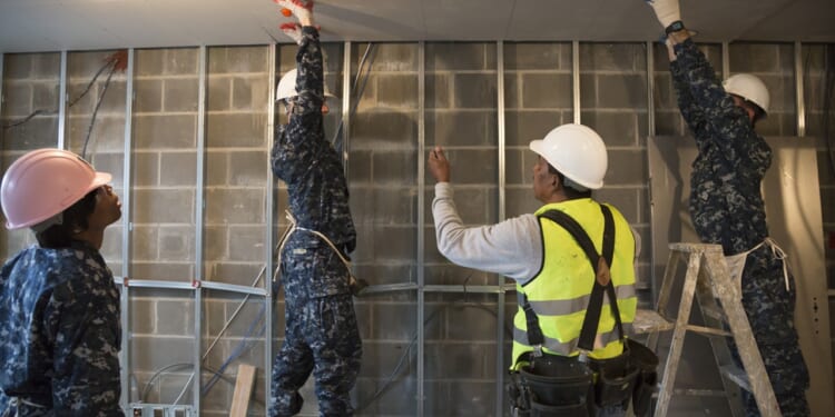 A group of soldiers participating in a construction project.