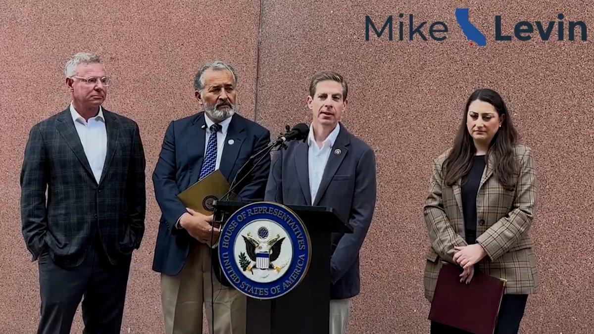 four representatives standing at podium during news conference