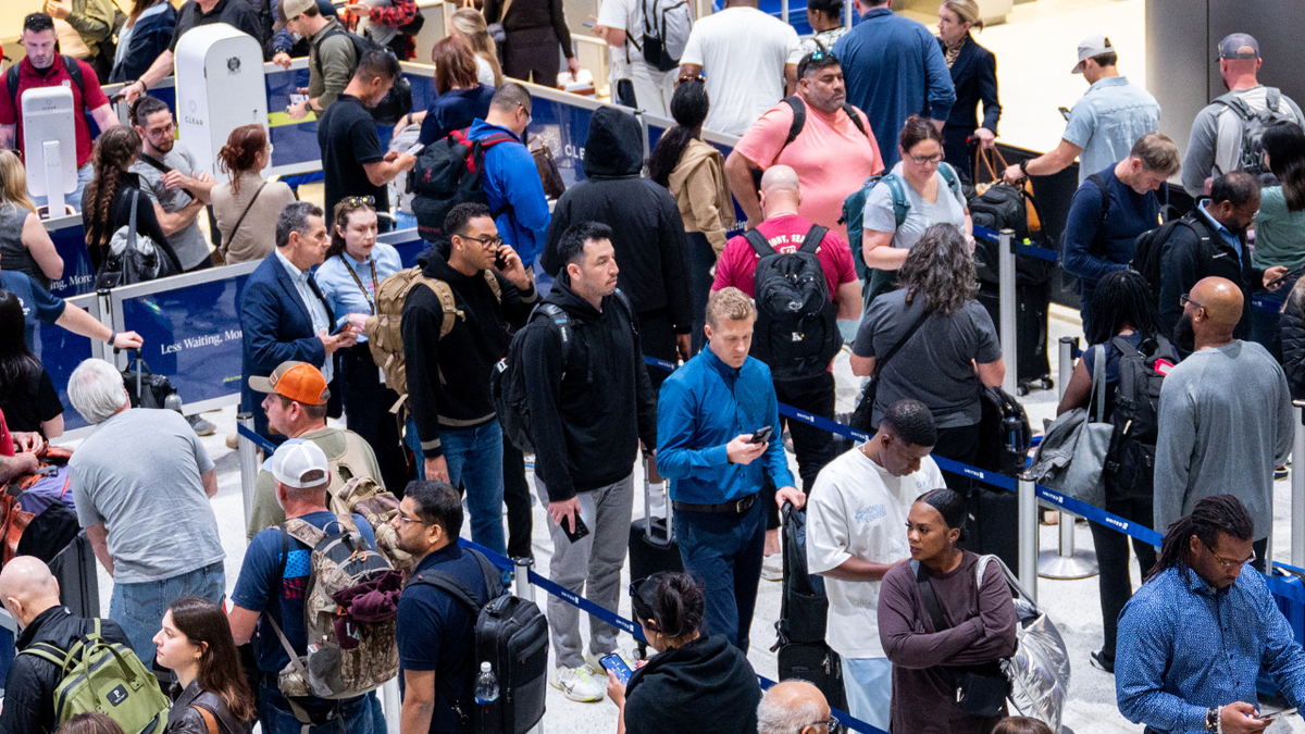 People wait in line at a security checkpoint at the George Bush Intercontinental Airport on November 6, 2025 in Houston, Texas.