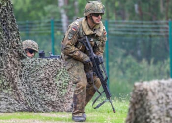 A German soldier carrying a gun.