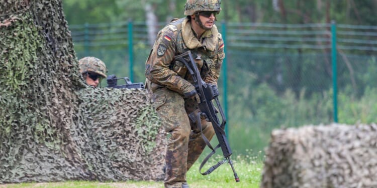 A German soldier carrying a gun.