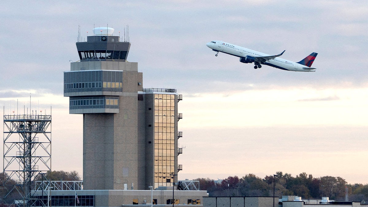 Plane takes off with air traffic control tower in view