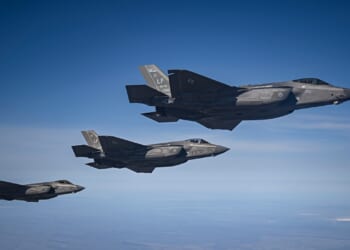 Three F-35 fighter jets in flight.