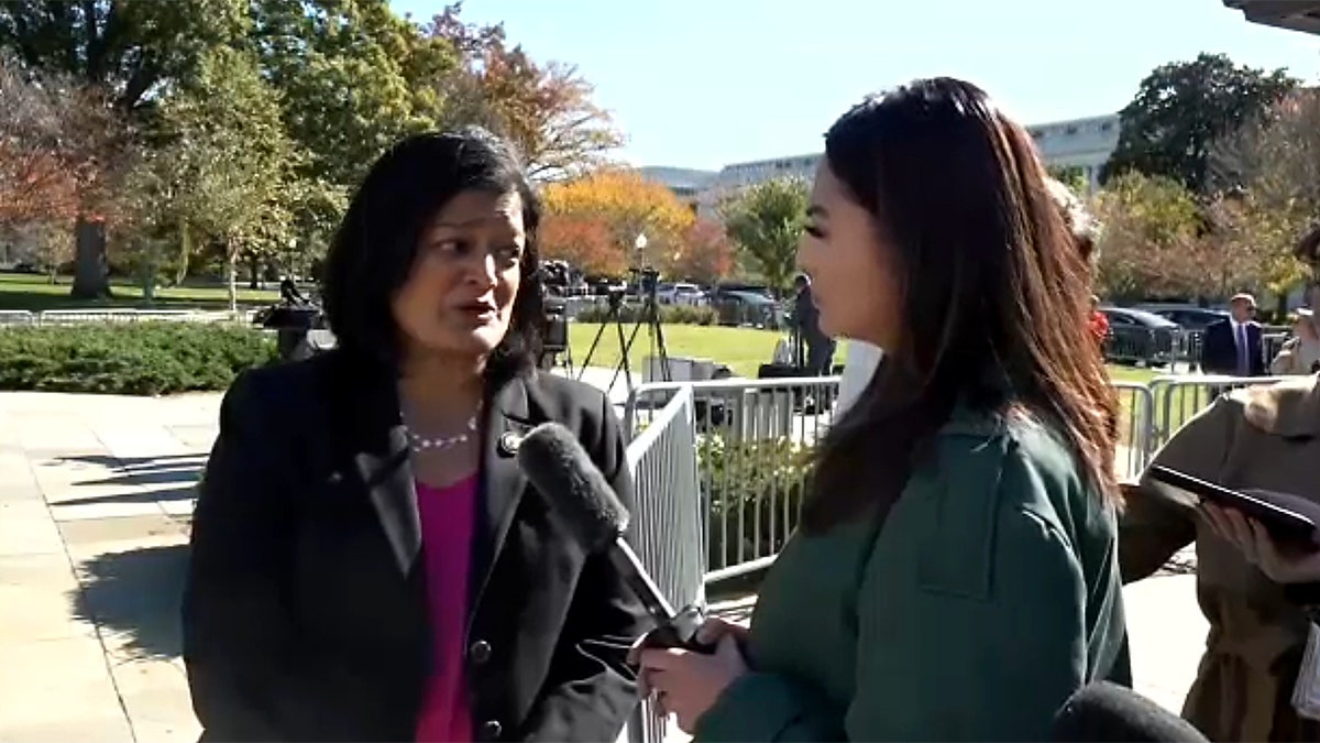 Aishah Hasnie holds a mic to Pramila Jayapal who is speaking.
