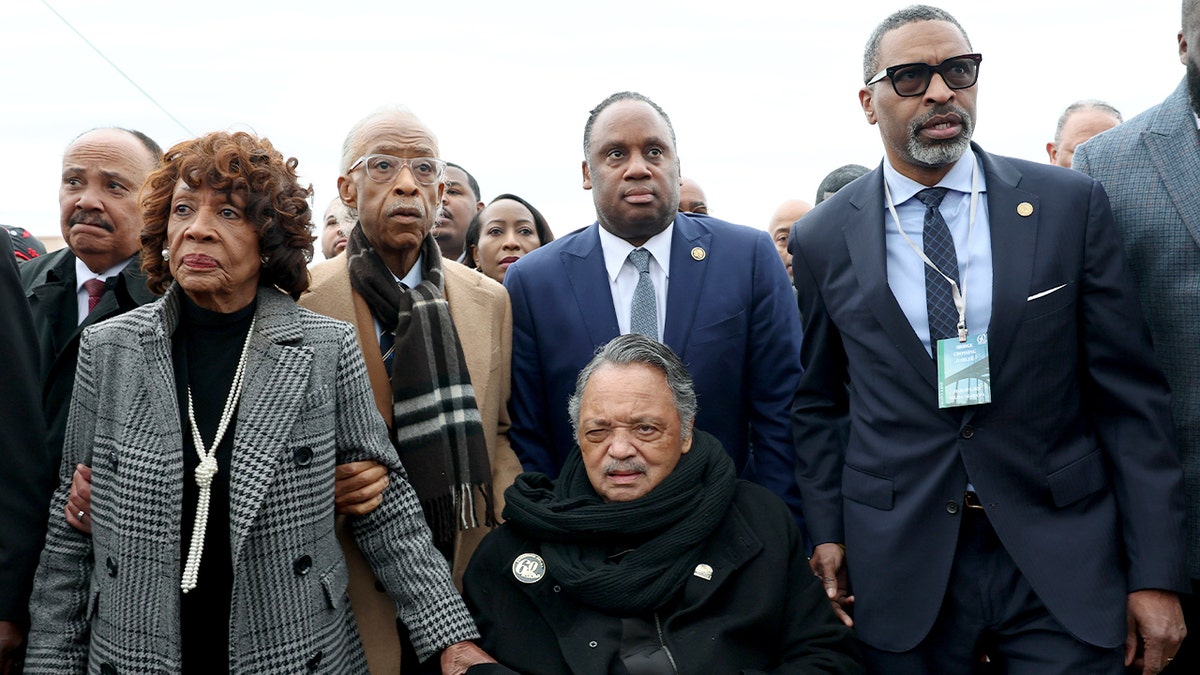 Civil rights leaders and lawmakers walk together across Edmund Pettus Bridge during a 60th anniversary commemoration of Bloody Sunday in Selma, Alabama.
