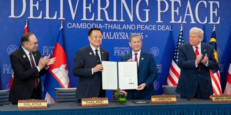 The leaders of Thailand and Cambodia signing a peace deal. Donald Trump to one side.