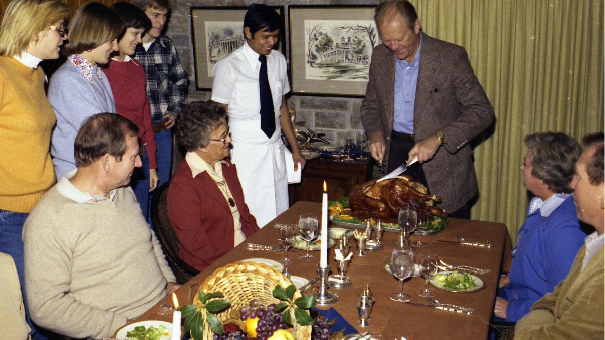 An archival photograph of President Gerald R. Ford carving a turkey at Camp David in November 1976.