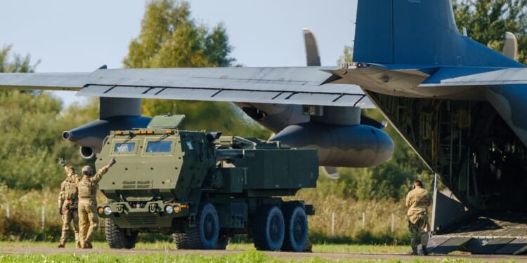 A HIMARS vehicle leaving a plane.