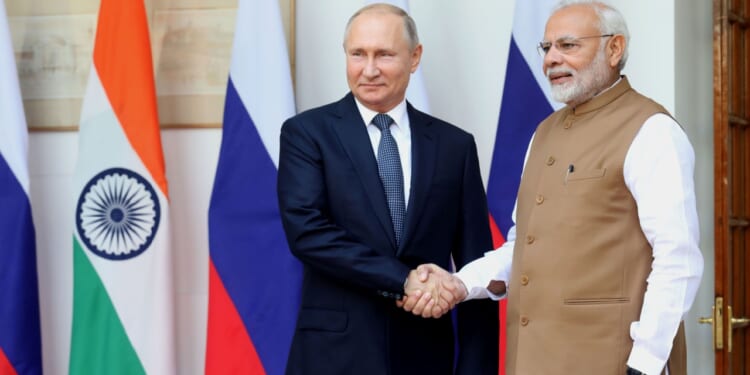 Russian president Vladimir Putin shakes hands with Indian prime minister Narendra Modi.