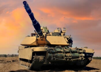 An Abrams tank in the field at dusk.