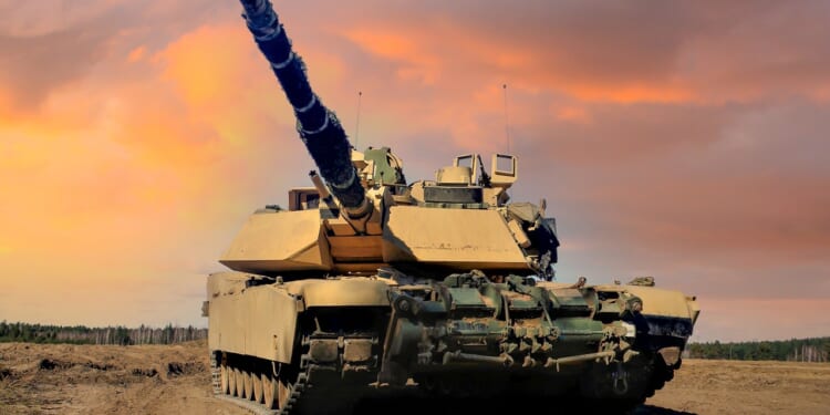 An Abrams tank in the field at dusk.
