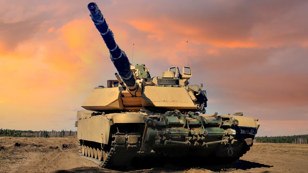 An Abrams tank in the field at dusk.