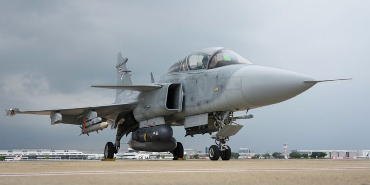 A JAS 39 Gripen fighter at an airfield.