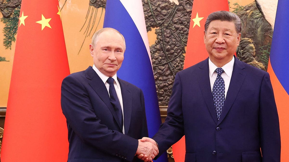 Chinese President Xi Jinping shakes hands with Russian President Vladimir Putin at the Great Hall of the People in Beijing