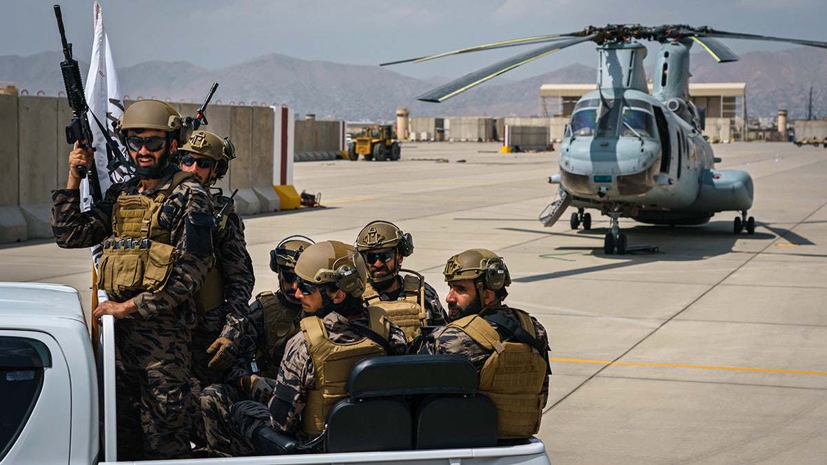 Taliban fighters ride in vehicle at Hamid Karzai International Airport