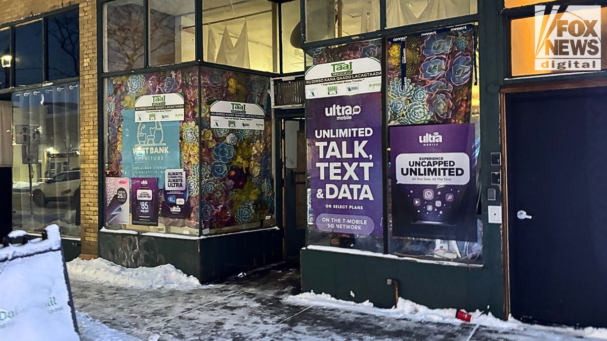 Taaj Money Transfer storefront at night in Cedar–Riverside, Minneapolis.