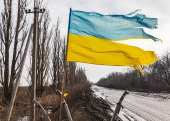 Ukrainian flag flies in a war zone. Ukraine War.