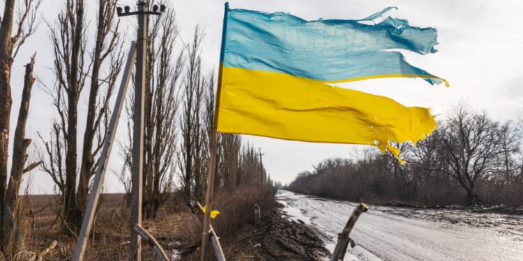 Ukrainian flag flies in a war zone. Ukraine War.