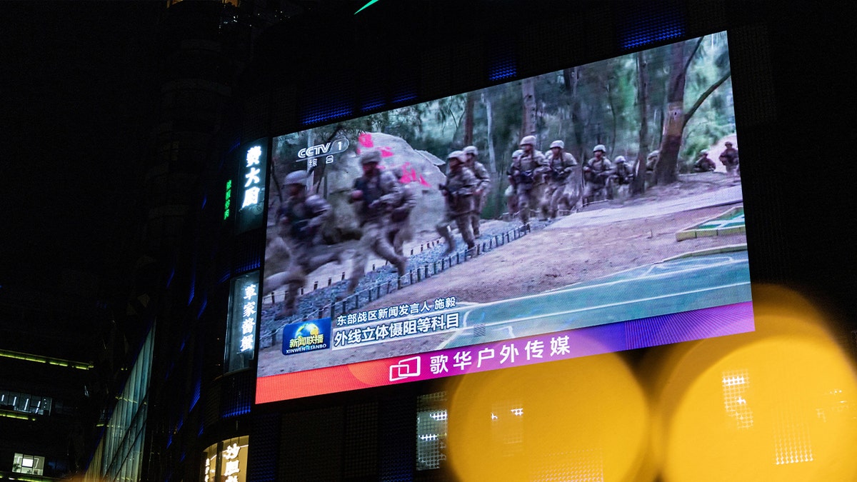 A giant city screen broadcasting news on China's military drills around Taiwan is seen through New Year decorations, in Beijing, China, December 29, 2025.