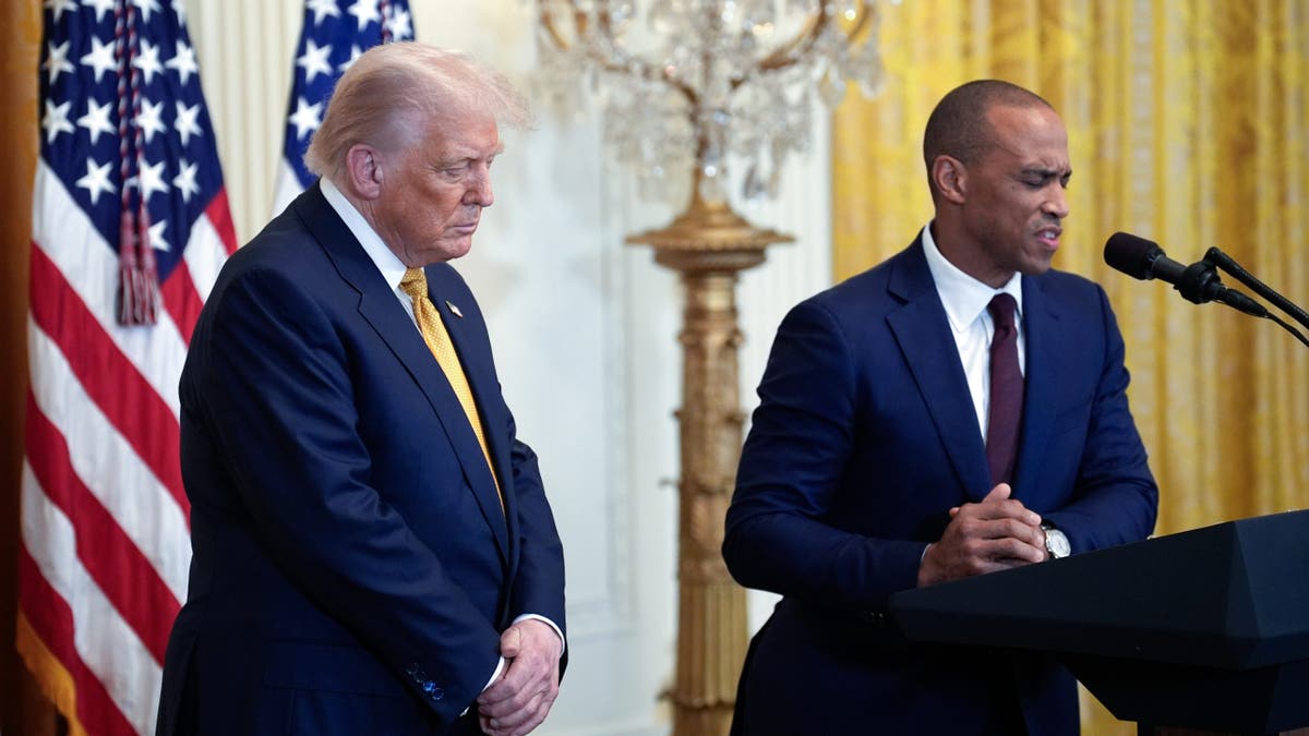 Secretary Scott Turner prays with President Donald Trump