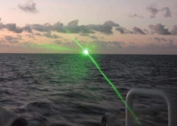 A Chinese Coast Guard ship firing a laser at a Philippine Coast Guard vessel.