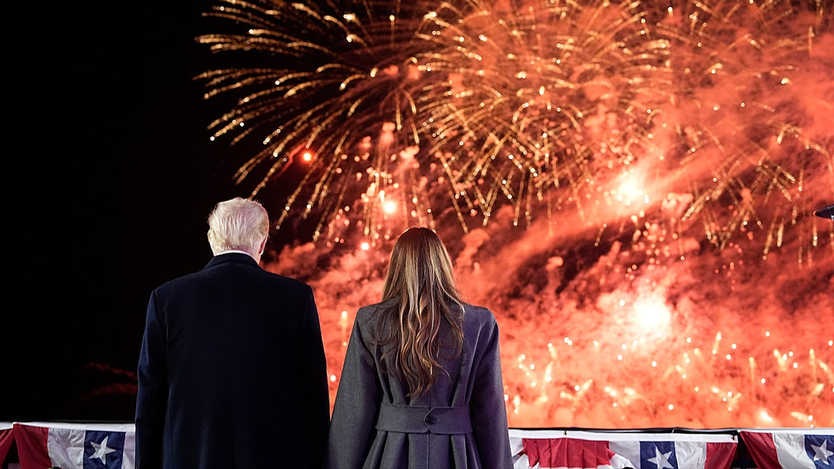 President Trump and first lady Melania Trump standing in front of fireworks