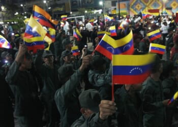 A group of Venezuelan soldiers carrying flags.